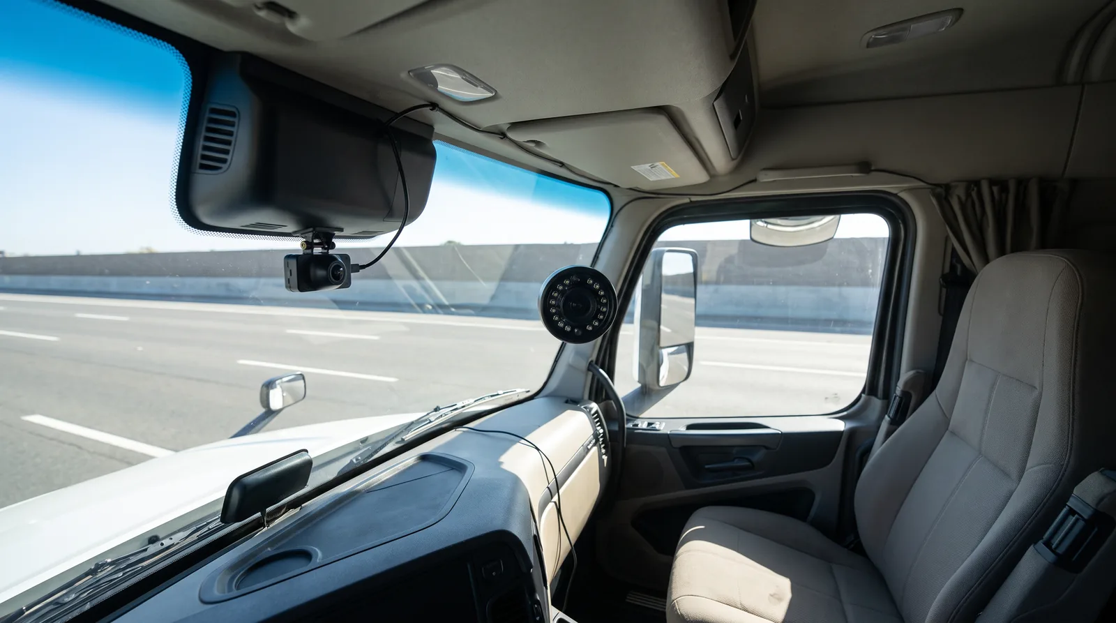 Interior de cabine com duas câmeras: uma no para-brisa apontada para a estrada e outra voltada para o assento do motorista
